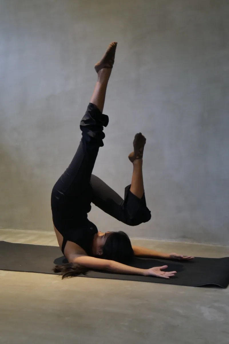 Allegra De Borja in a shoulder stand variation on the mat at Holding Space Siargao