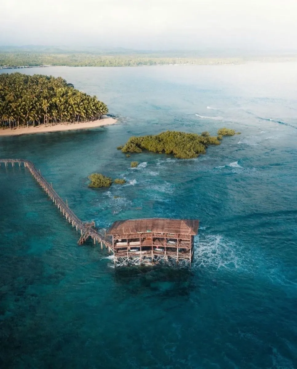Aerial view of the Cloud 9 boardwalk and palm-covered island in Siargao
