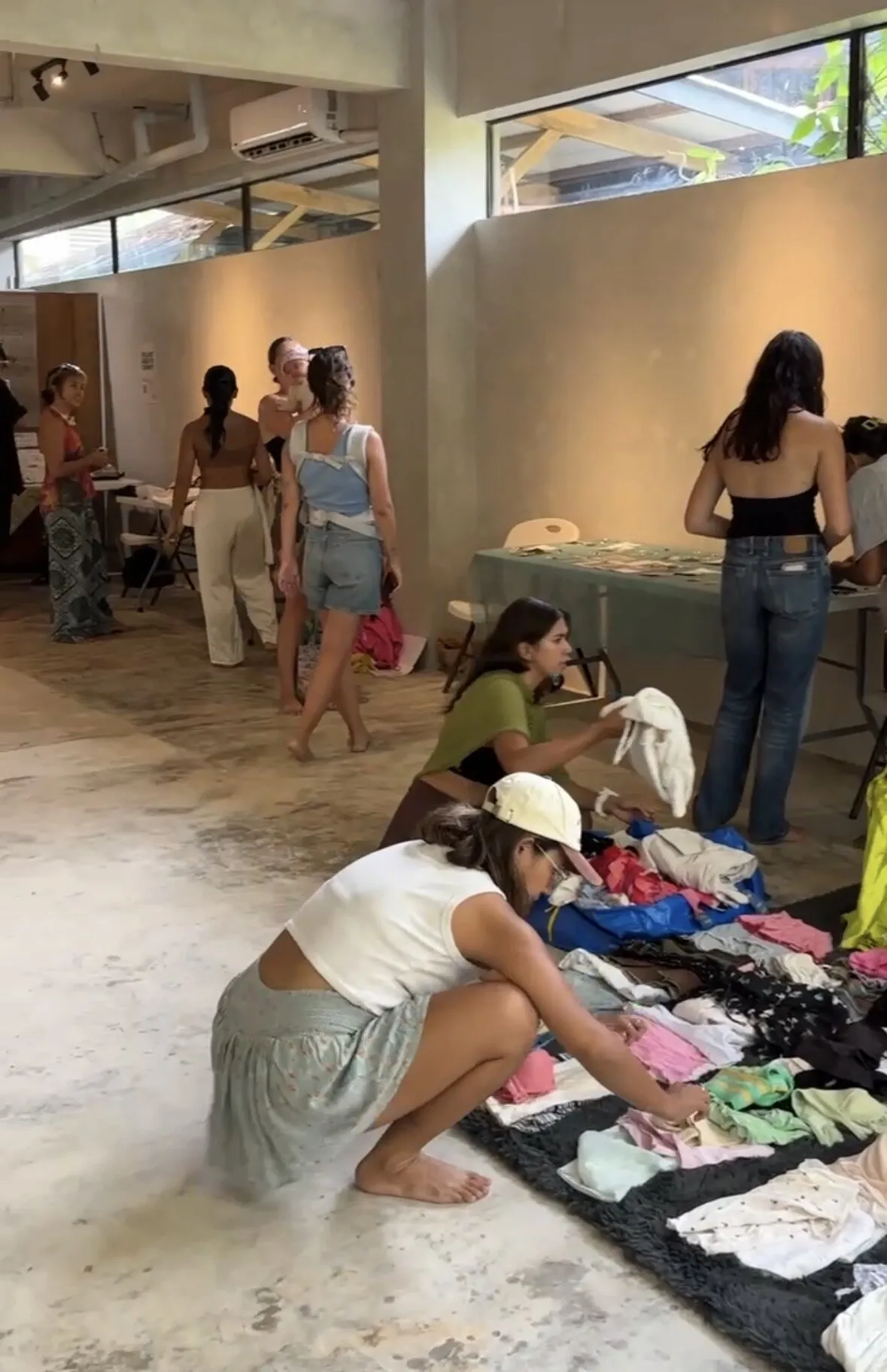 Flea market with clothes laid out on the floor of Holding Space