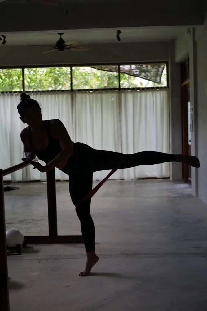Silhouette of barre arabesque with resistance band at Feral Movement studio