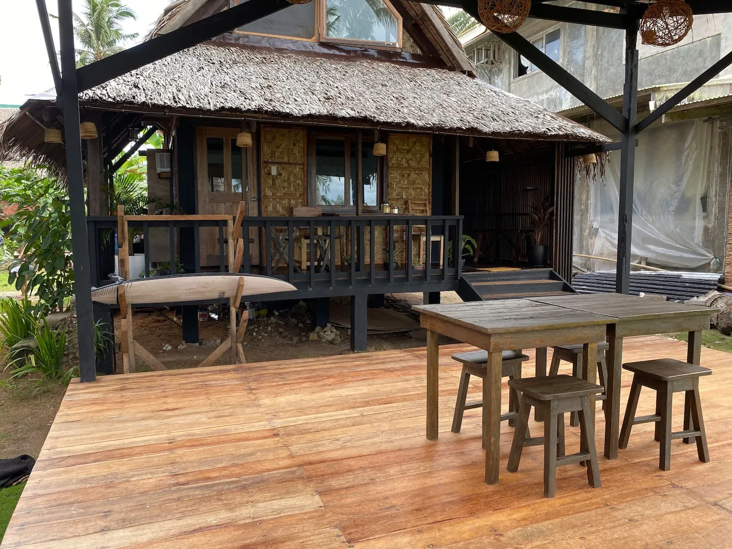 The wooden deck and traditional nipa-roof facade of Vultun House, a beachfront villa on Jacking Horse Beach, General Luna, Siargao