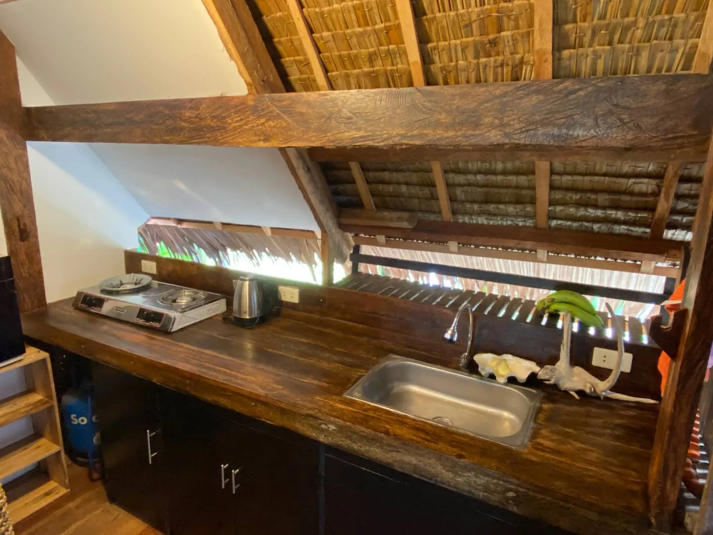 The full kitchen tucked beneath the bamboo A-frame ceiling at Vultun House