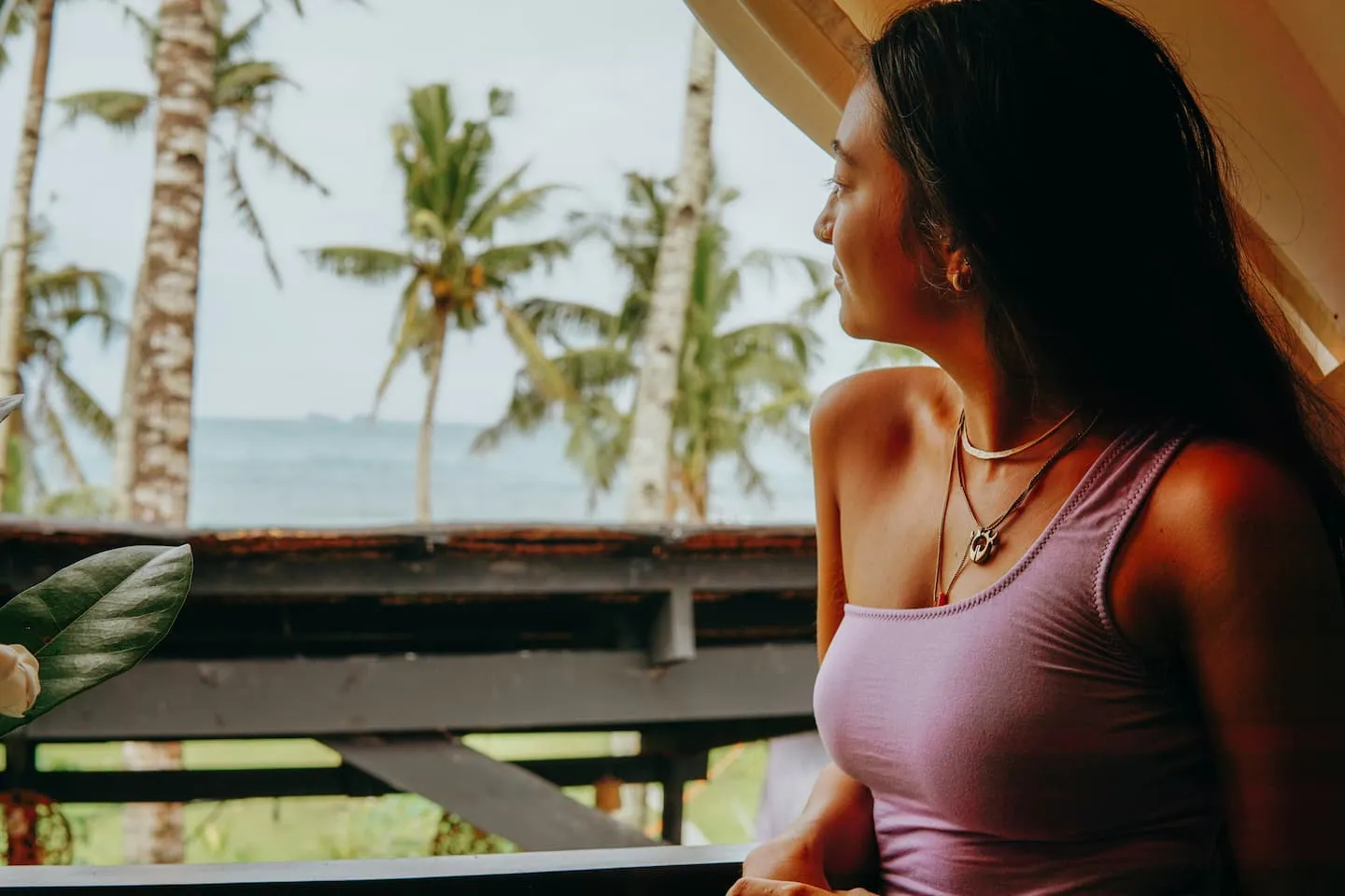 A guest looking out from the deck of Vultun House toward the palms and ocean at Jacking Horse Beach, Siargao