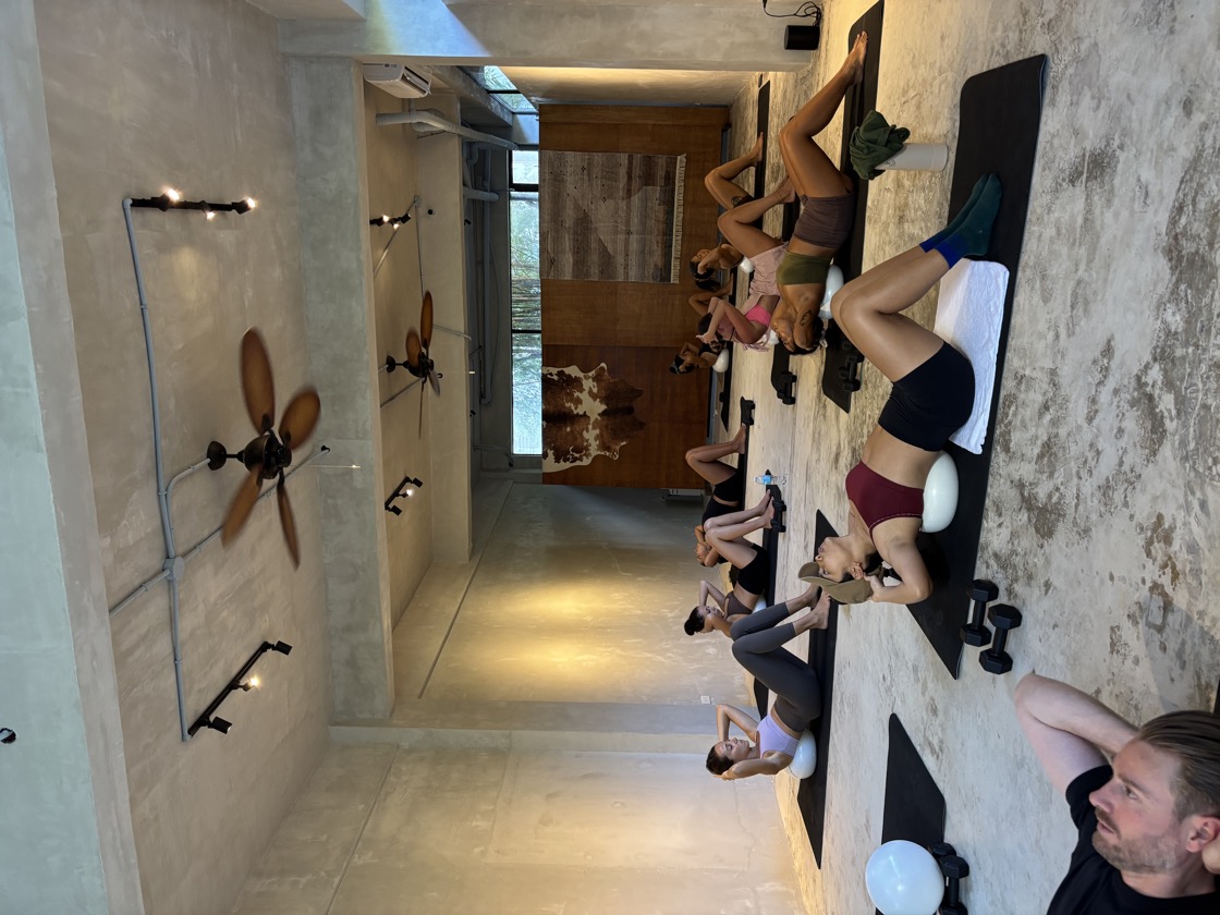 Group mat Pilates class doing crunches with barre balls at Feral Movement studio Siargao