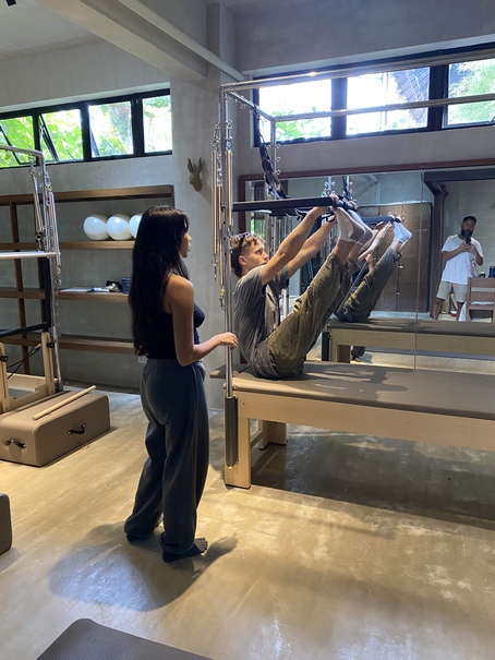 Allegra guiding a client on the Cadillac trapeze at Feral Pilates studio