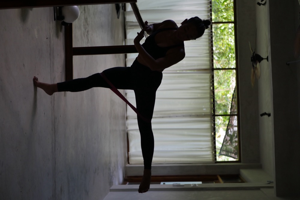 Silhouette of barre arabesque with resistance band at Feral Movement studio